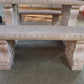 Stone bench with intricate carvings on a concrete floor