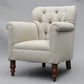 Beige armchair with wooden legs on a gray background