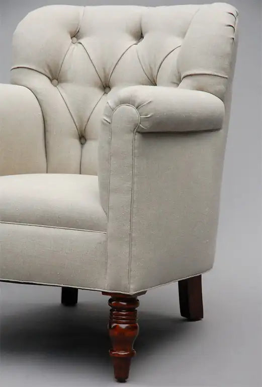 Beige armchair with wooden legs on a gray background