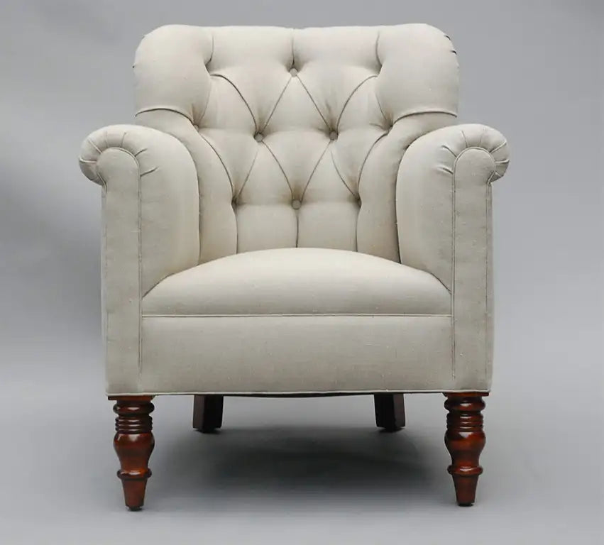 Beige armchair with wooden legs on a gray background