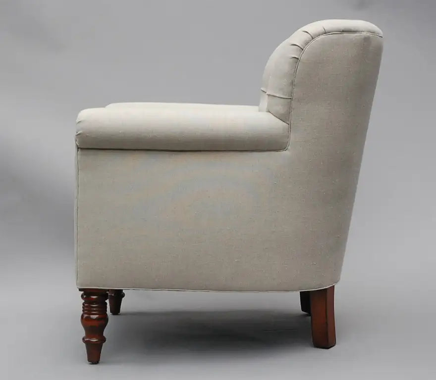 Beige armchair with wooden legs on a gray background