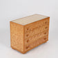 Wooden dresser with woven pattern on a white background