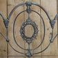 Decorative metal headboard with intricate designs on a wooden background