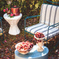 Outdoor setting with a chair, small table, and decorative items in a garden.