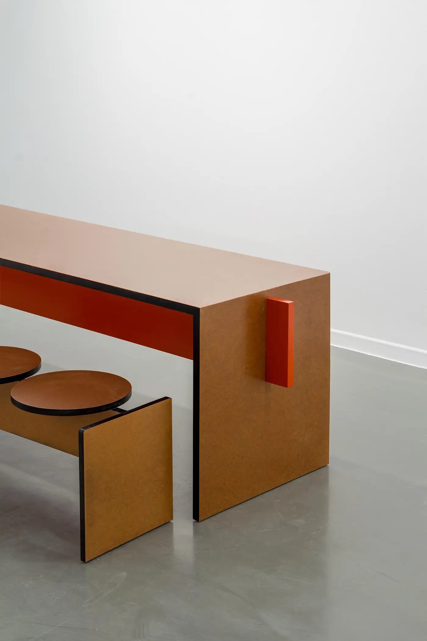 Modern wooden bench with red accent on a white background