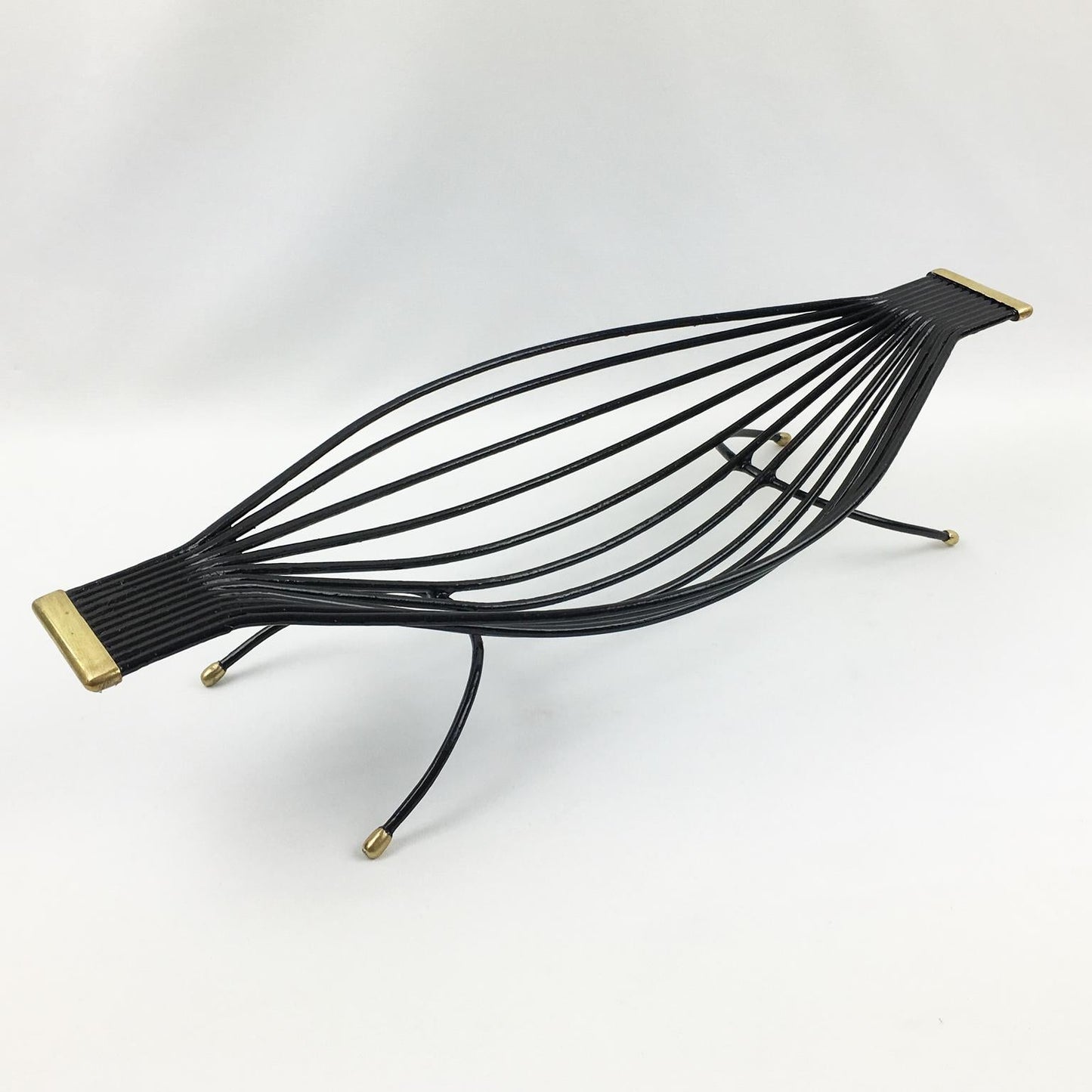 Black wire hammock with gold accents on a white background