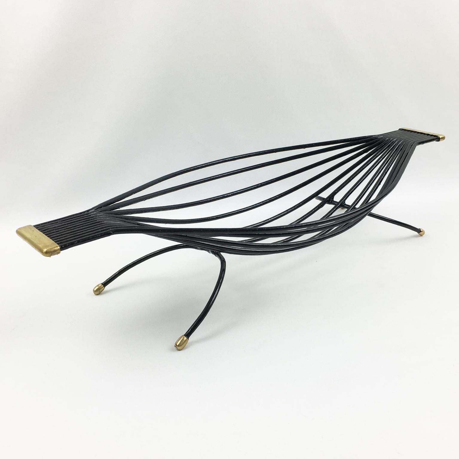 Black wire bird sculpture with gold accents on a white background