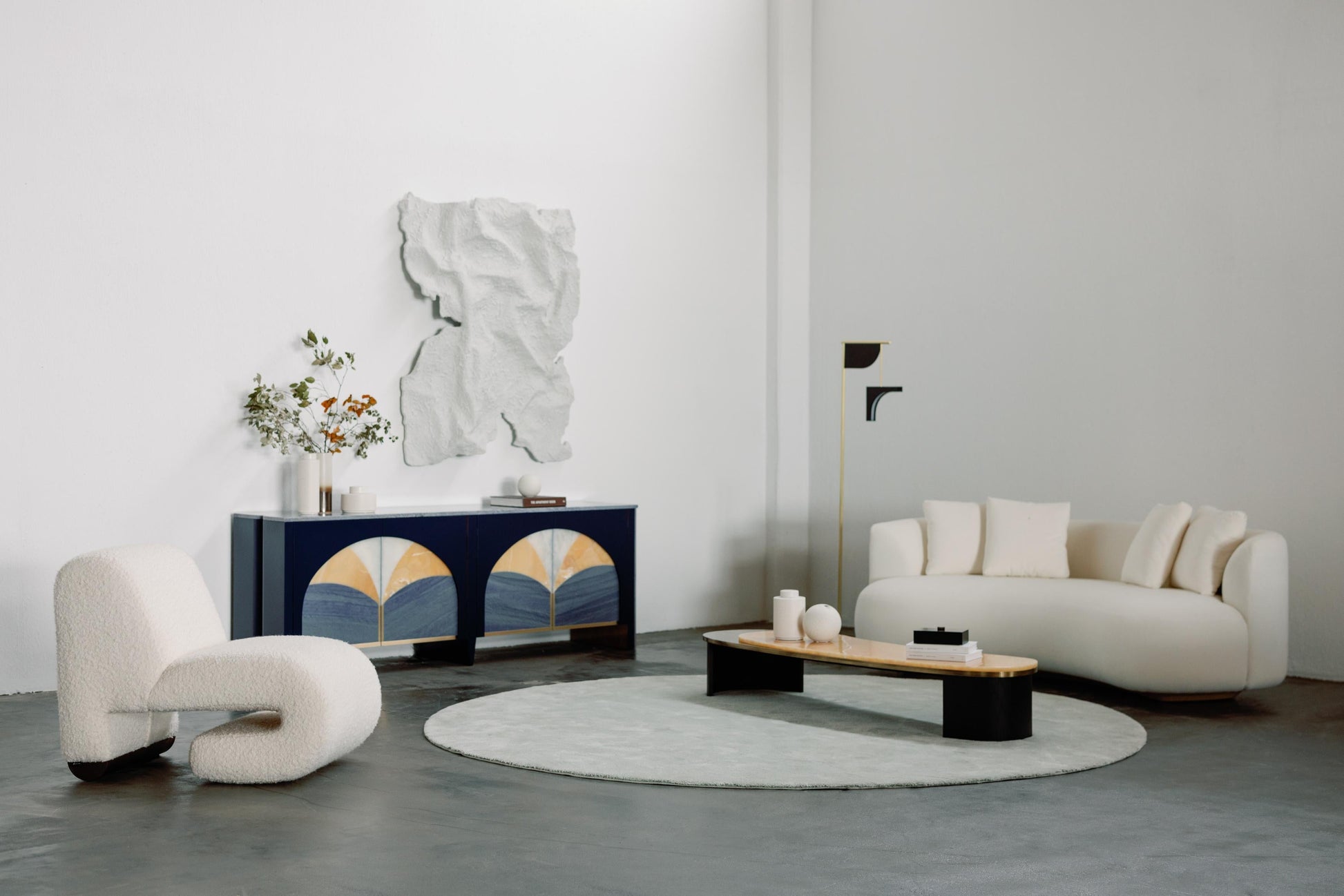 Modern living room with white sofa, armchair, and decorative cabinet.