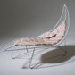 Modern lounge chair with pink cushion on a gray background