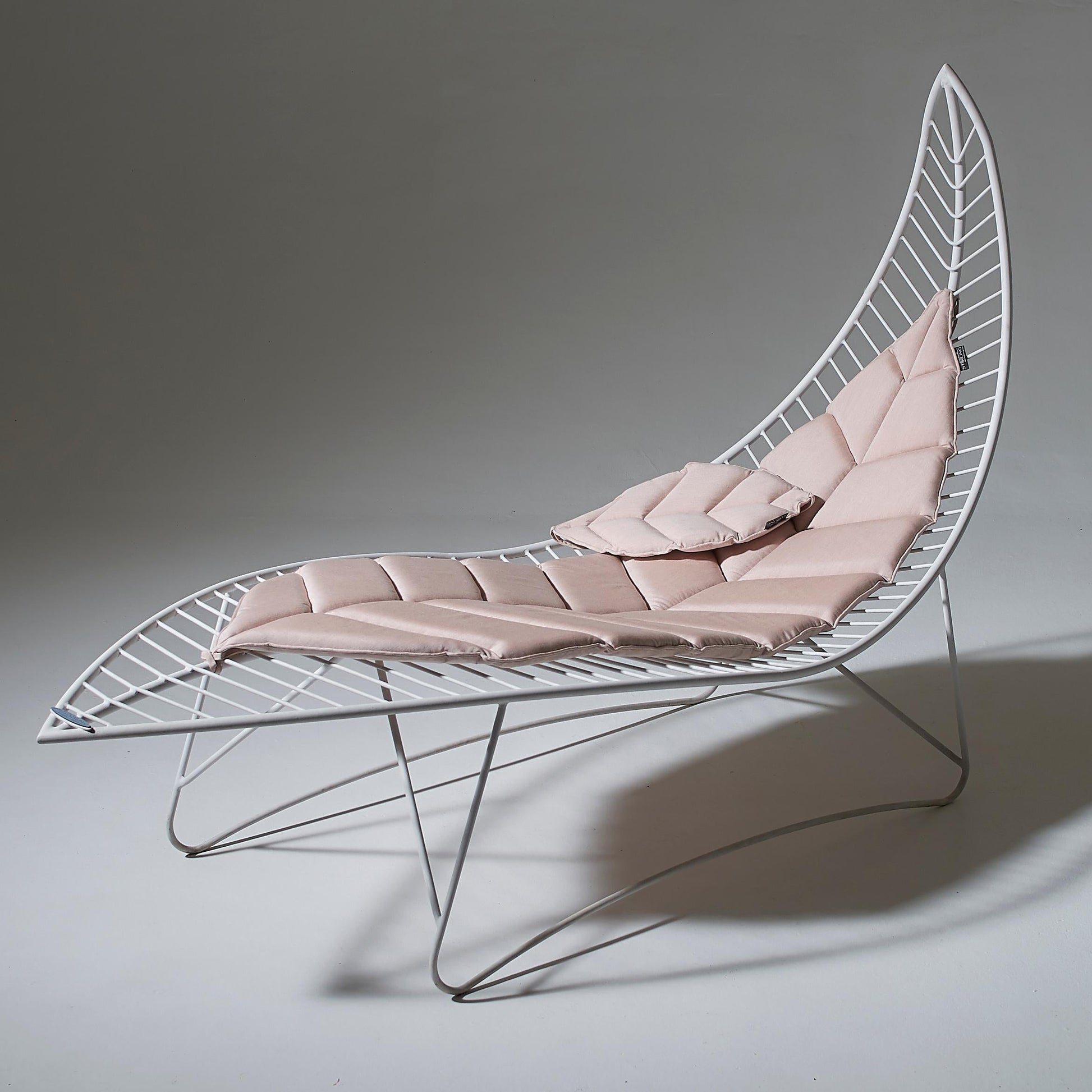 Modern lounge chair with pink cushion on a gray background