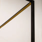 Close-up of a black and gold geometric art piece on a white wall.