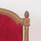 Close-up of a chair with gold frame and red velvet seat on a white background