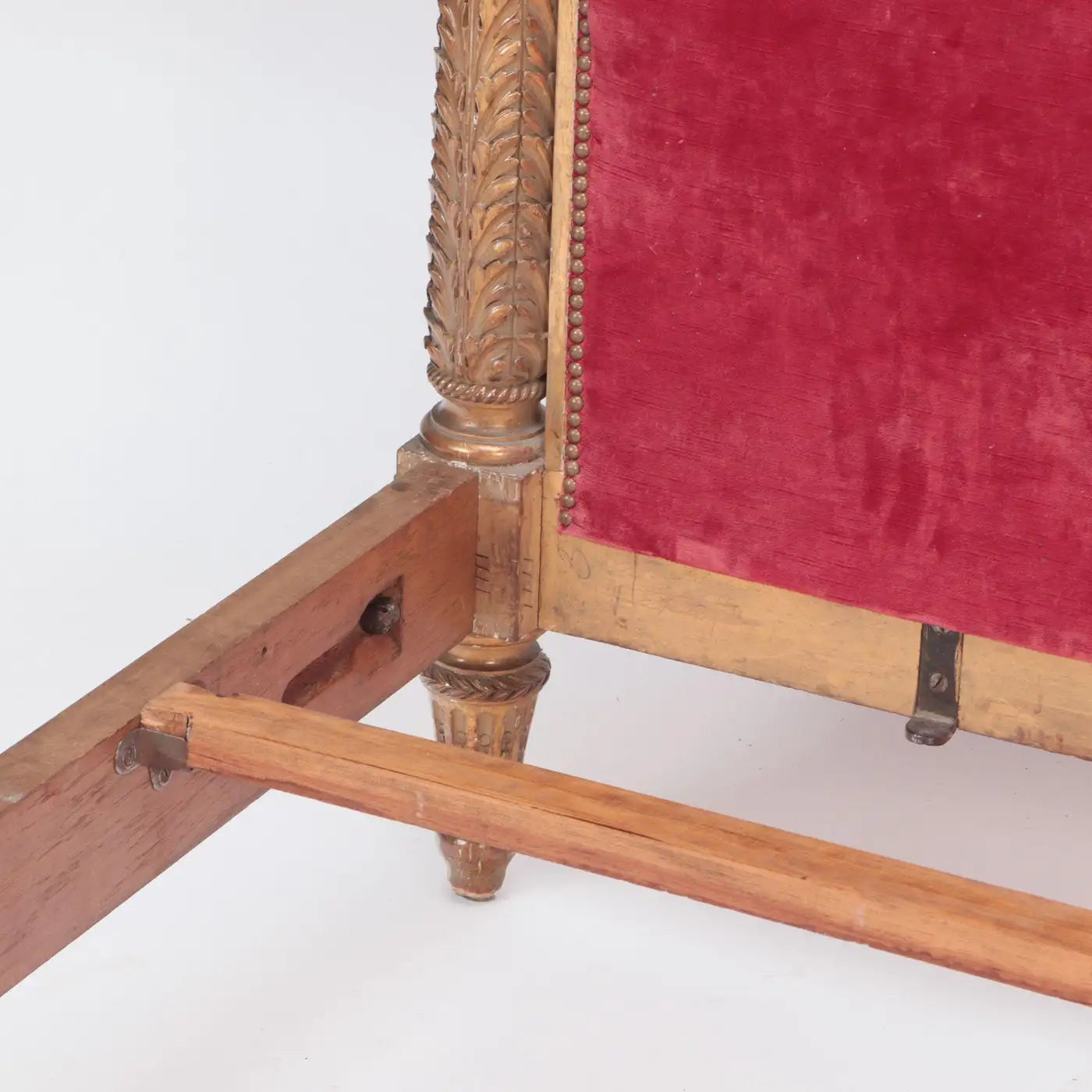 Close-up of a wooden chair with red velvet seat on a white background