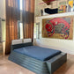 Modern bedroom with a unique bed design and colorful wall art.