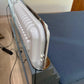 White iron on a stand with a blue ironing board in the background