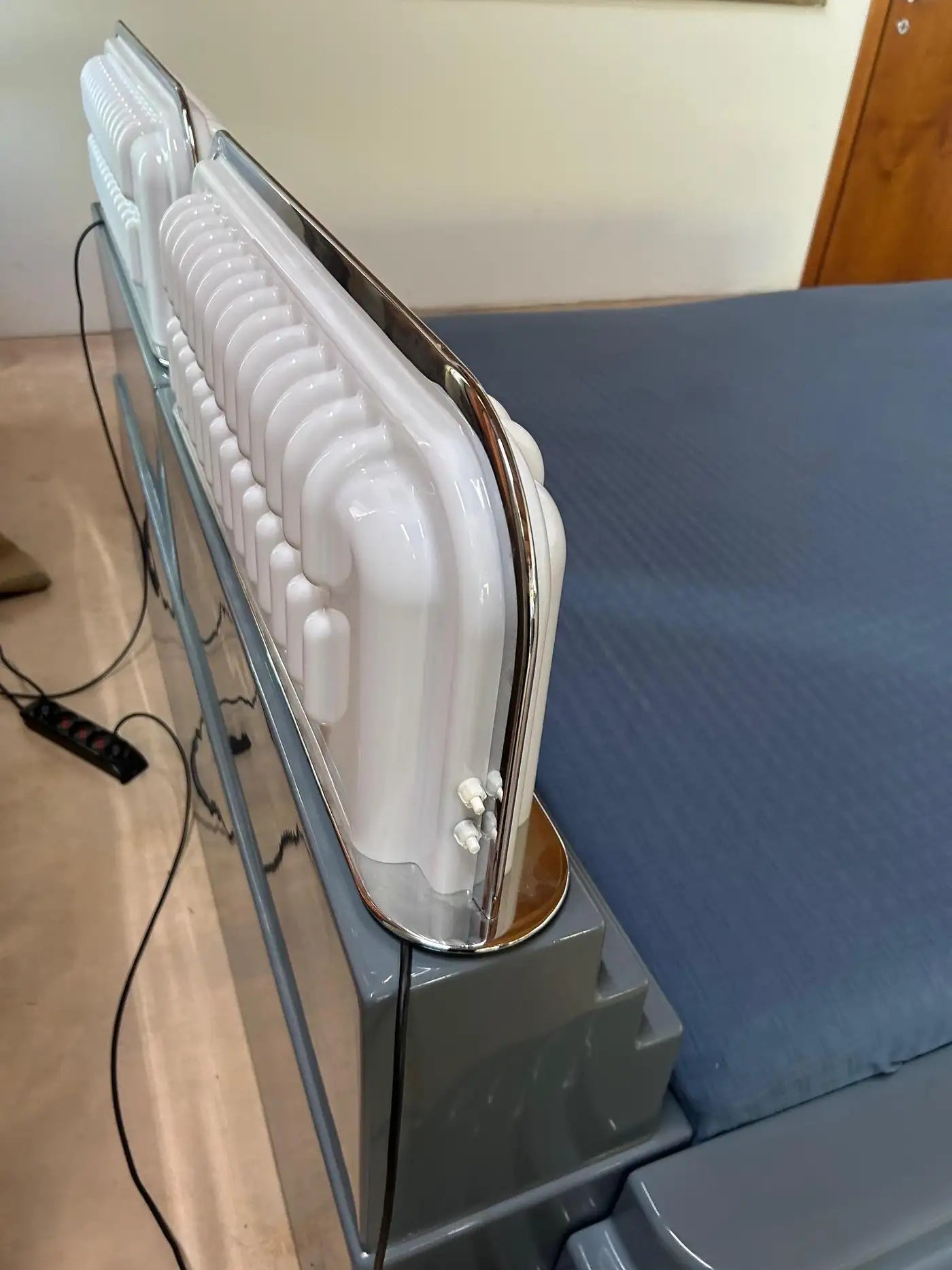 White iron on a stand with a blue ironing board in the background