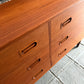 Wooden dresser with multiple drawers on a concrete floor