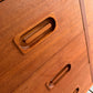 Close-up of a wooden drawer with handles on a wooden cabinet.