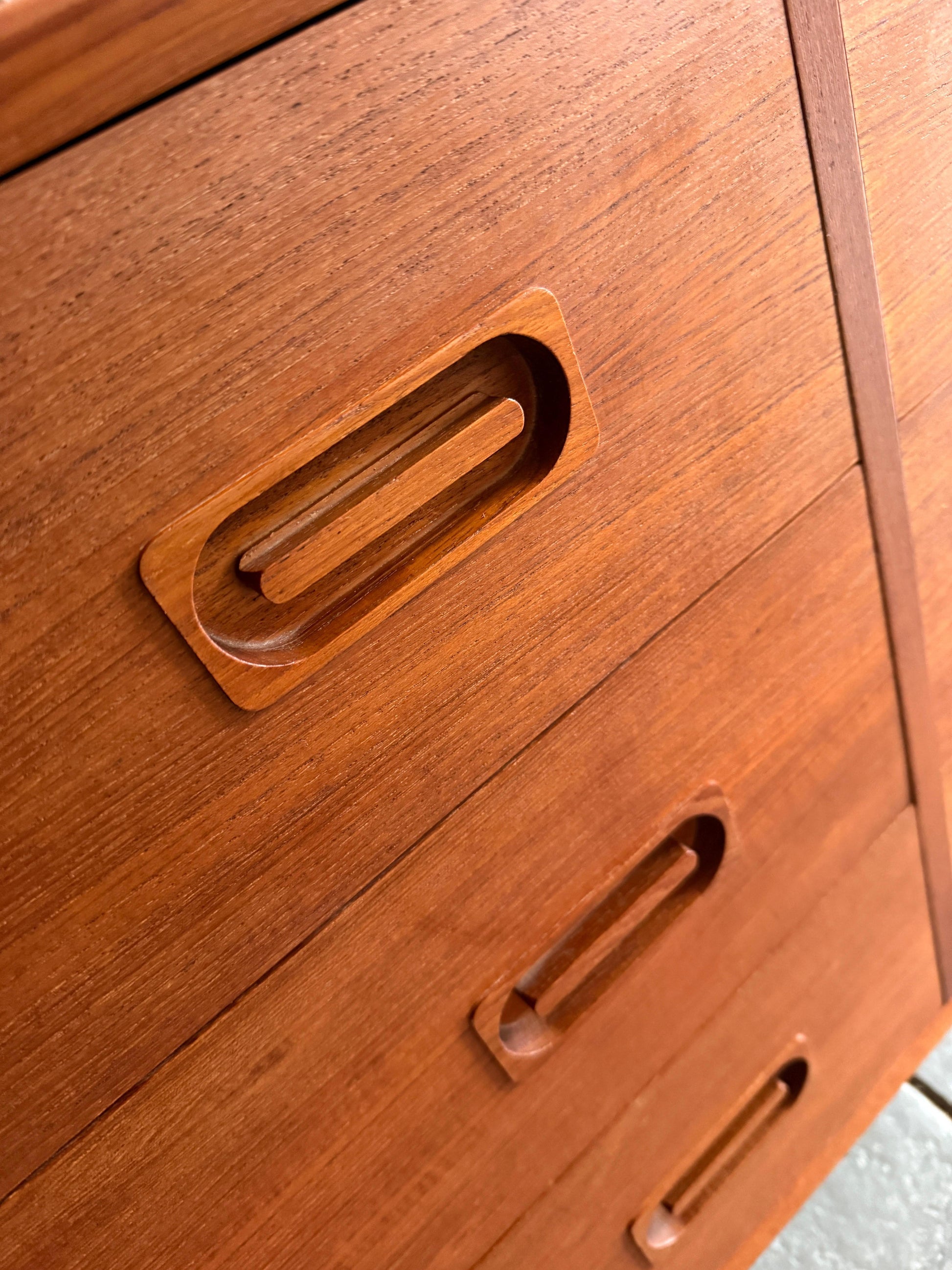 Close-up of a wooden drawer with handles on a wooden cabinet.