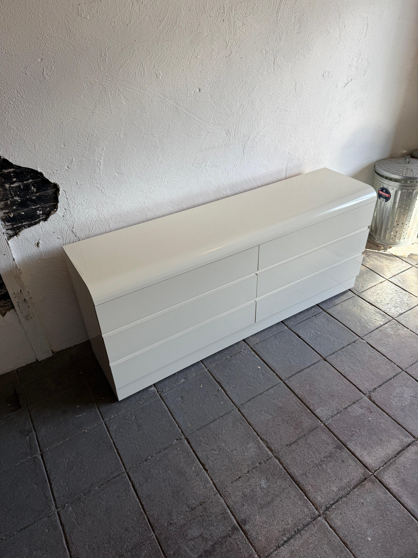 White storage box on a tiled floor against a white wall