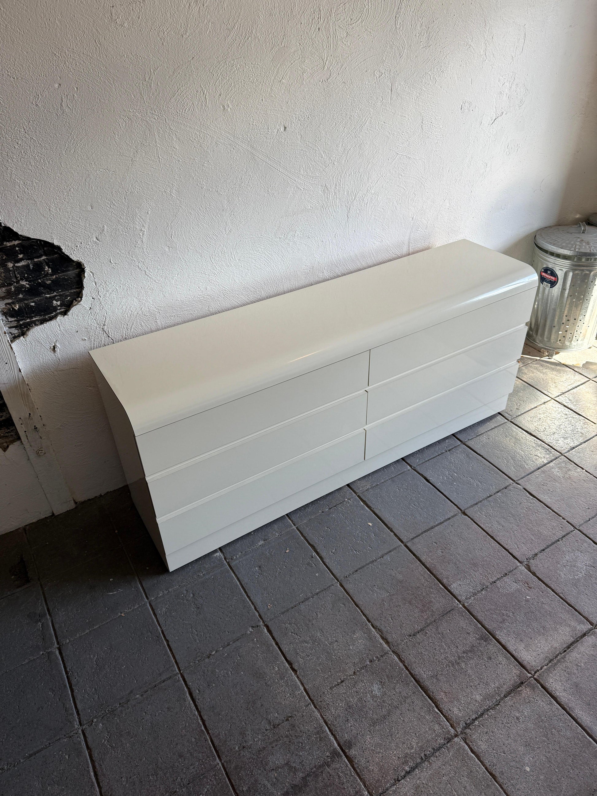 White storage box on a tiled floor against a white wall