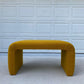 Mustard yellow bench in front of a white garage door