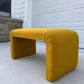 Yellow bench on a concrete surface with a garage door in the background