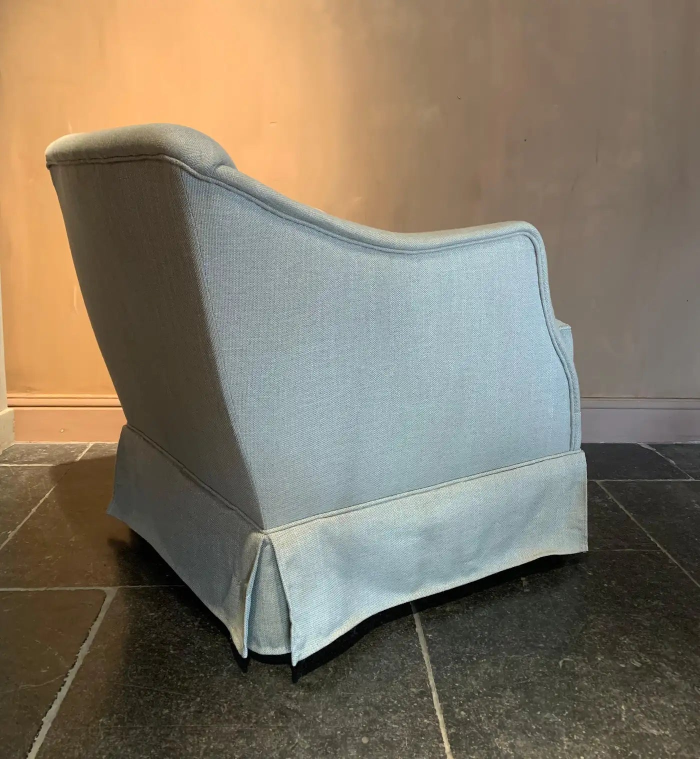 Light blue upholstered chair against a plain wall.