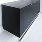 Black sideboard with drawers on a white floor and wall