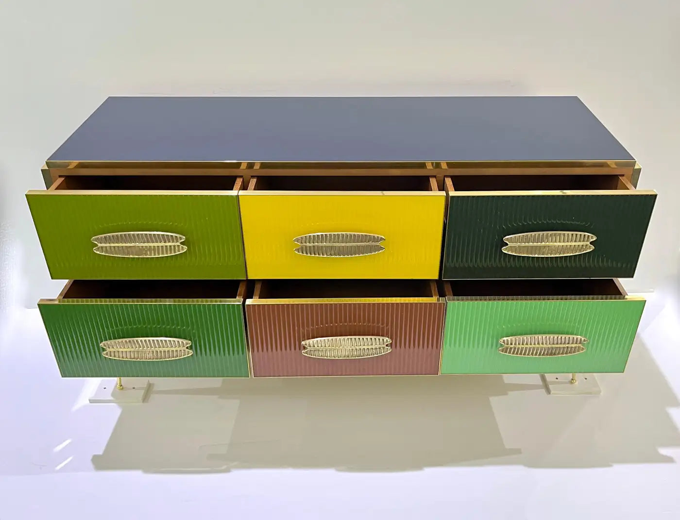 Colorful dresser with six drawers in green, yellow, and brown on a white background