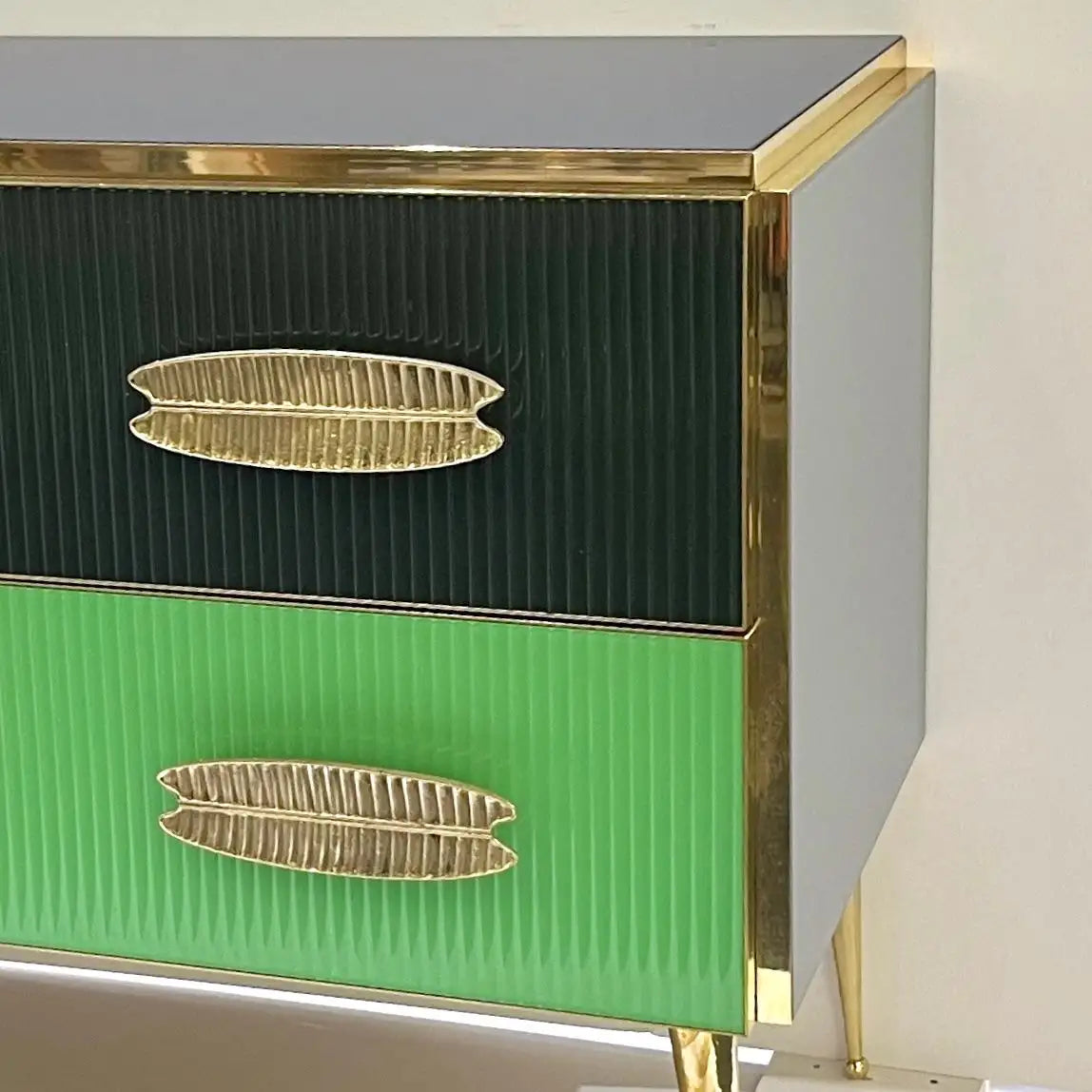 Green and gray cabinet with gold leaf handles on a white background