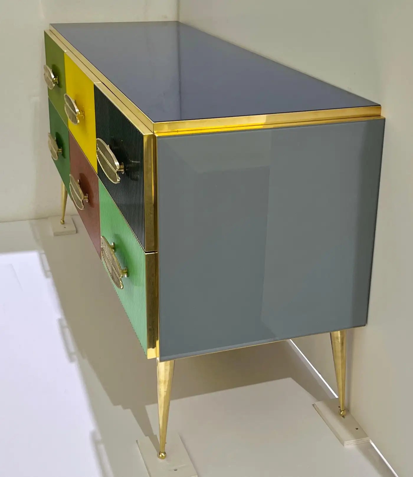 Multicolored dresser with gold accents on a white background