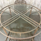 Round glass dining table with metal frame on a concrete floor