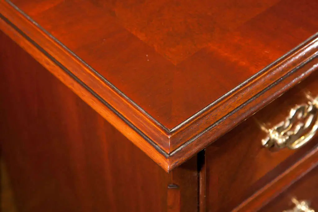 Close-up of a wooden desk with a gold handle