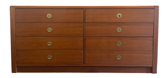 Wooden dresser with multiple drawers and brass knobs on a white background