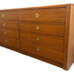 Wooden dresser with multiple drawers and brass handles on a white background