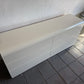 White rectangular object on a tiled floor against a white wall