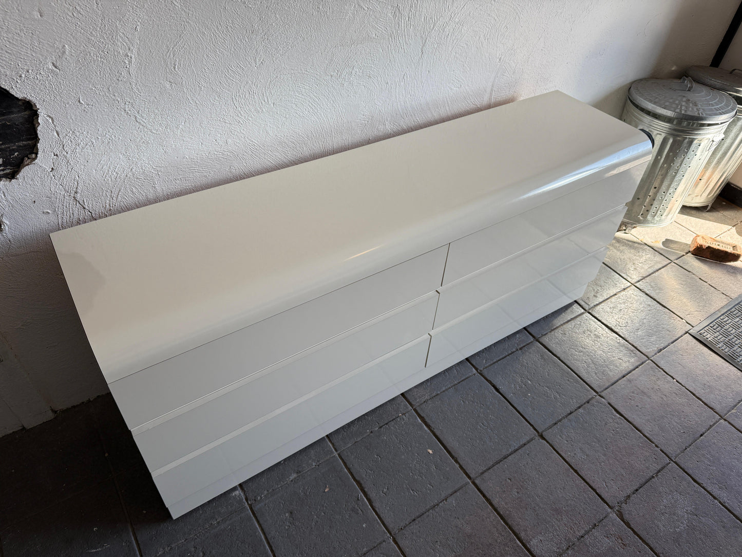 White rectangular object on a tiled floor against a white wall