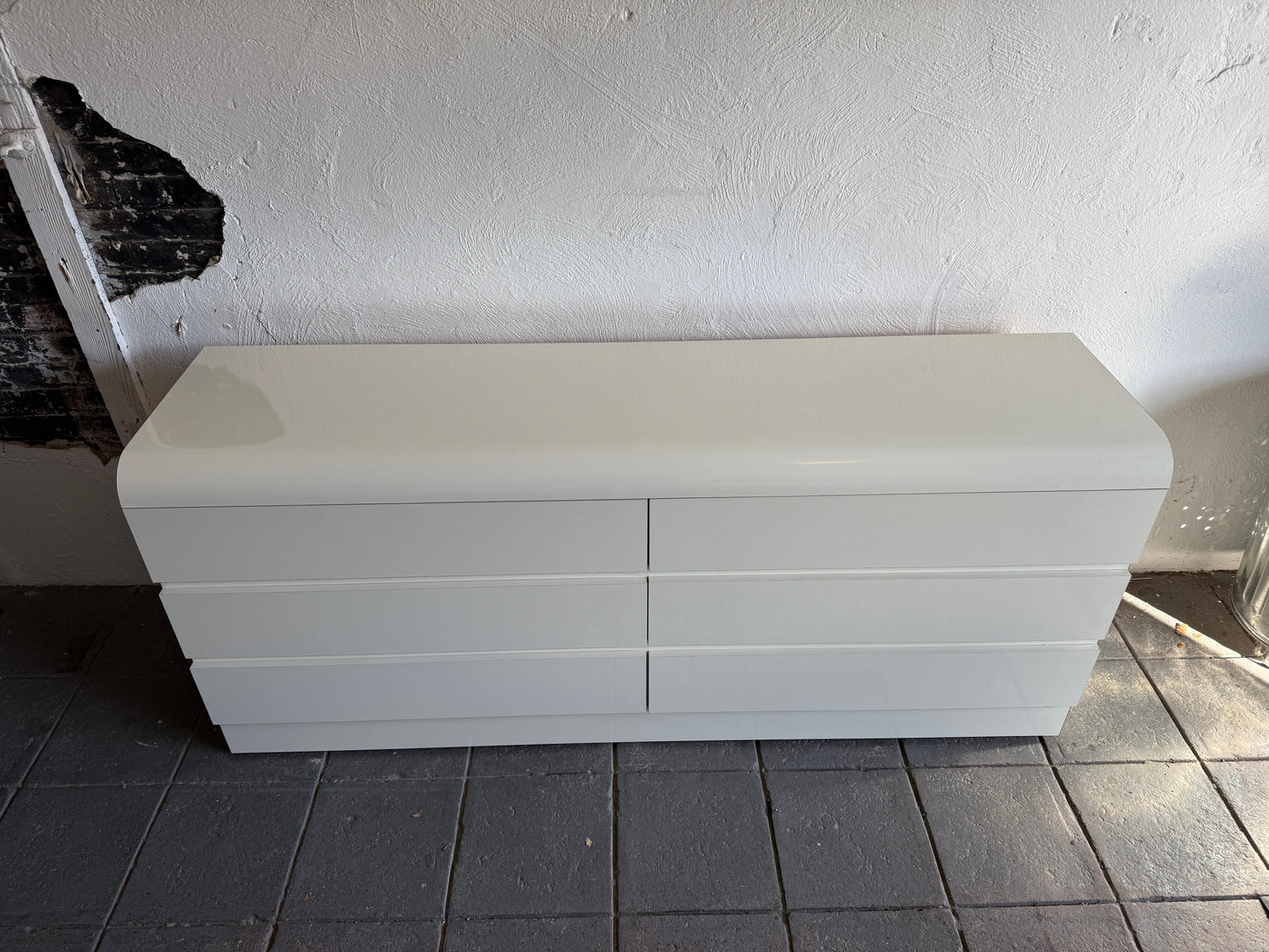 White storage bench against a white wall