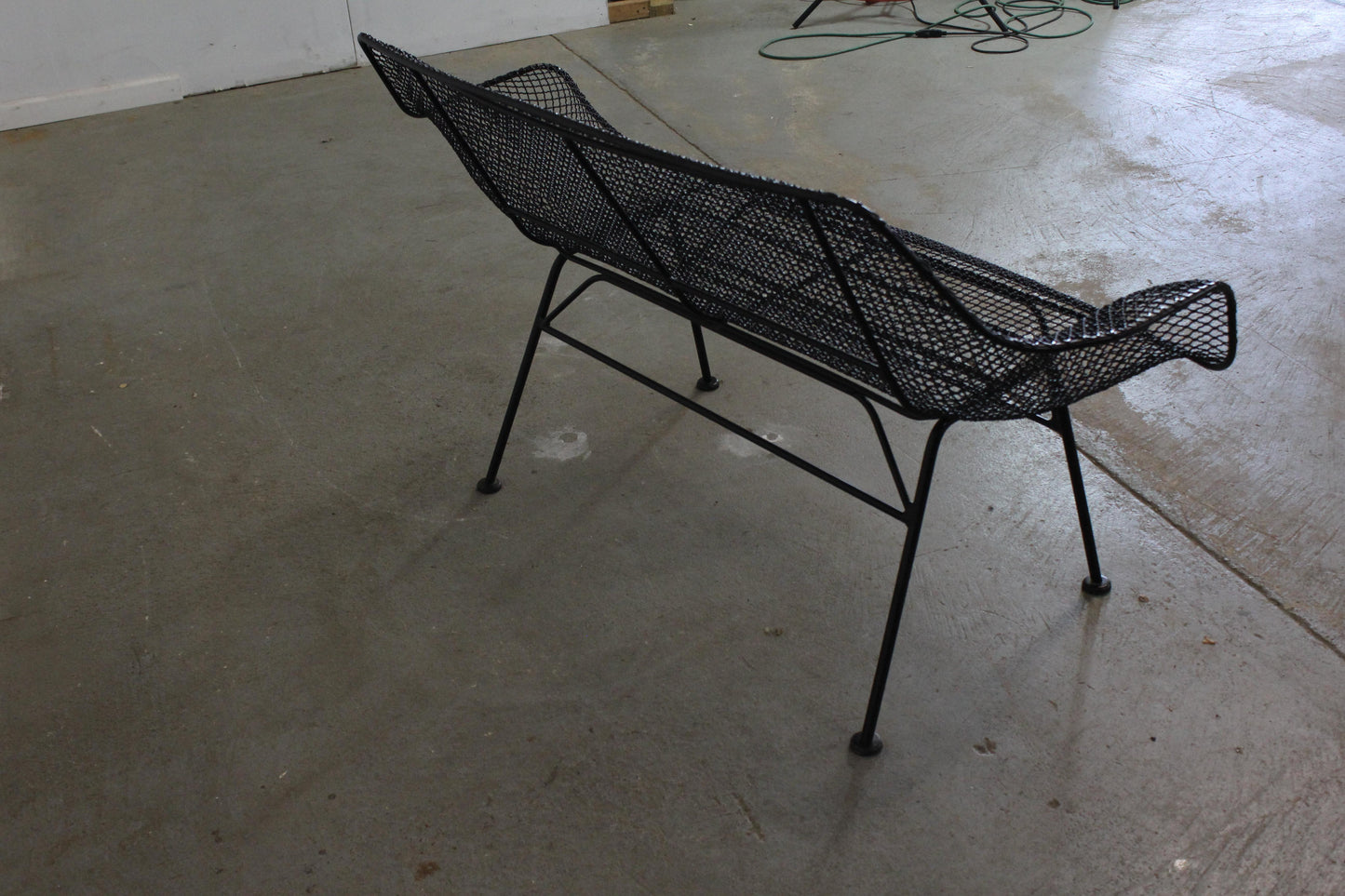 Black wire chair on a concrete floor