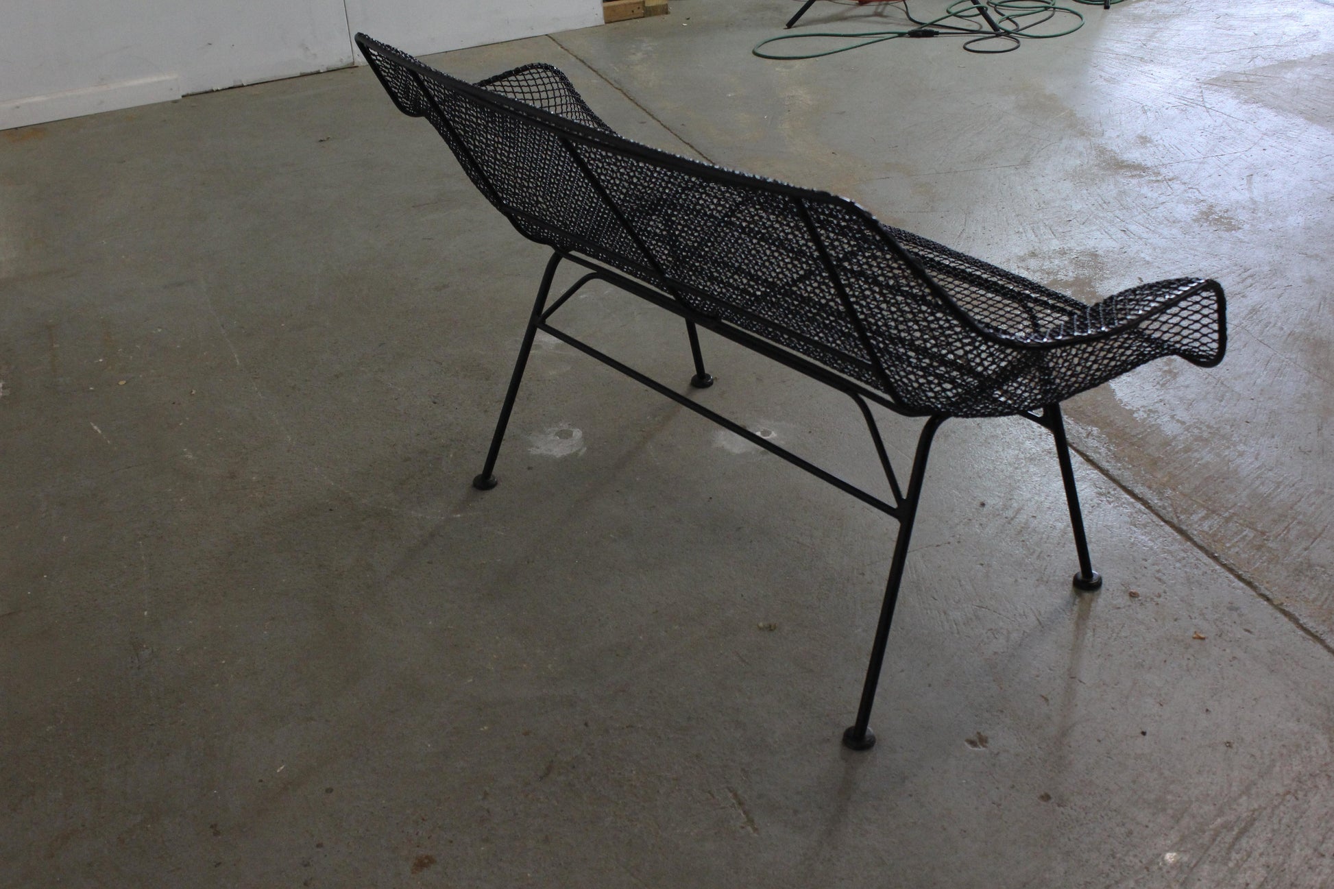 Black wire chair on a concrete floor
