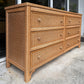 Wicker dresser with multiple drawers on a concrete surface