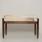 Wooden bench with patterned cushion on a white background