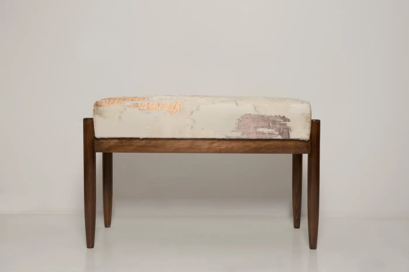 Wooden bench with patterned cushion on a white background