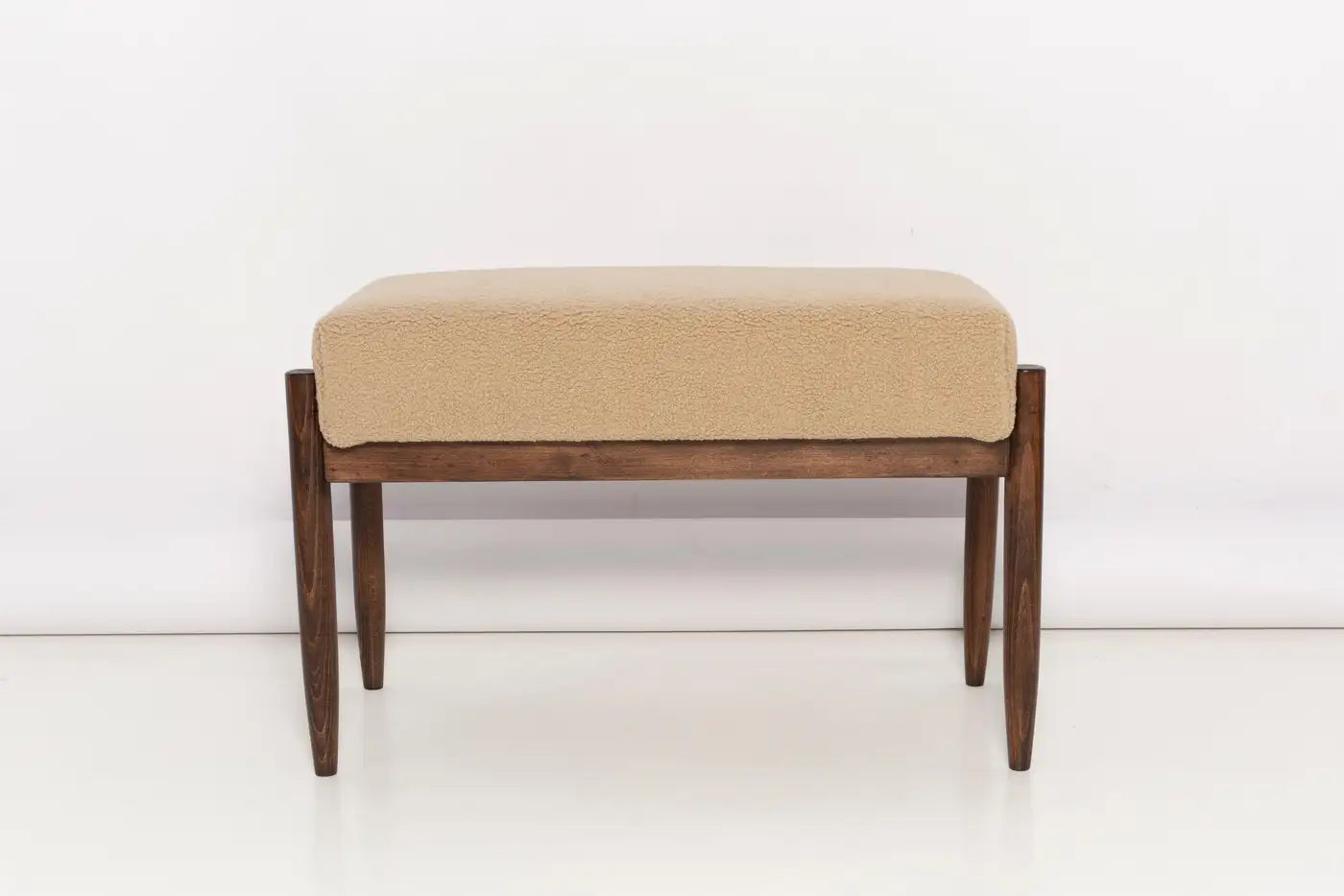 Beige cushioned bench with wooden frame on a white background