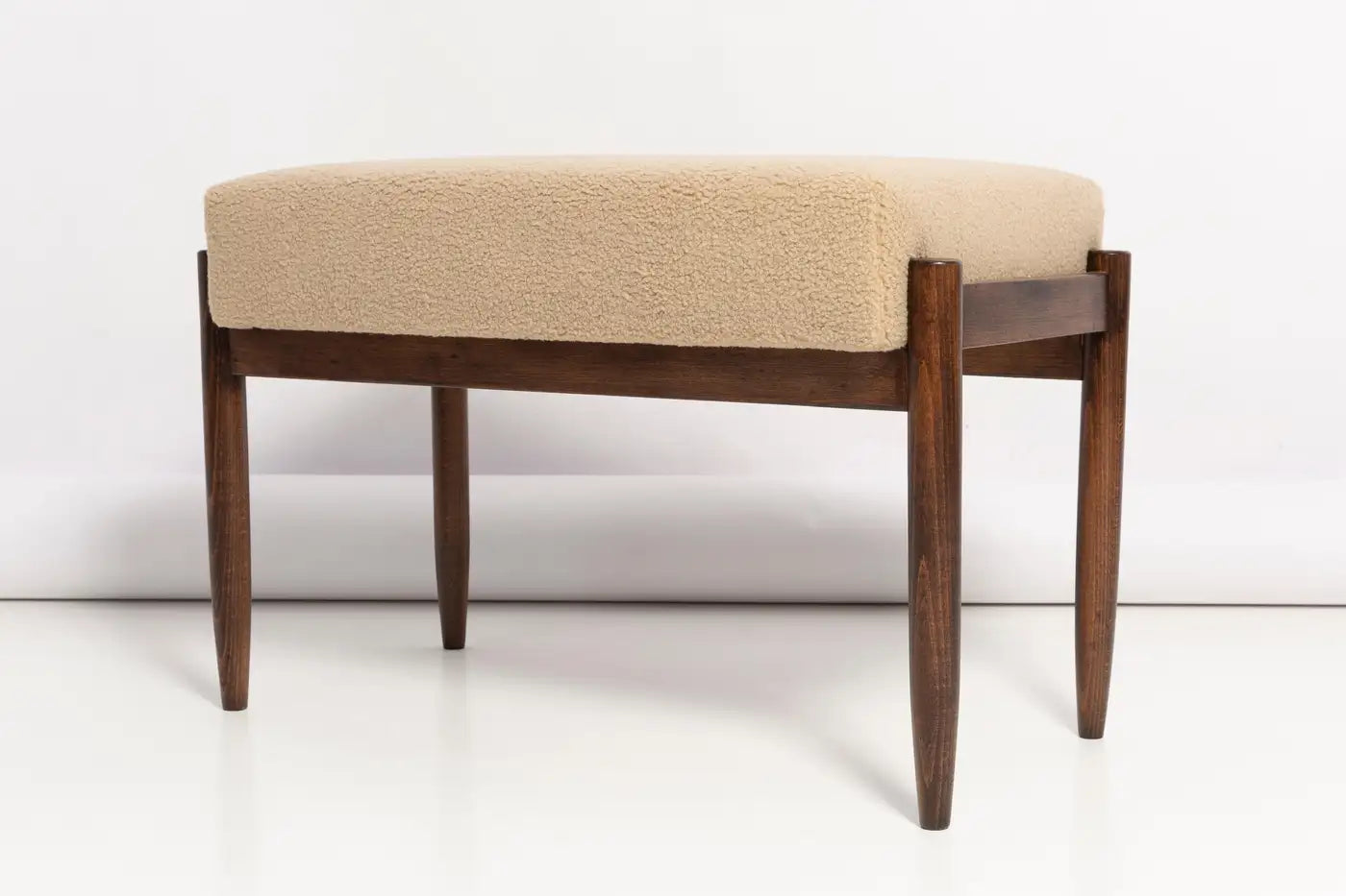 Wooden bench with beige cushion on a white background