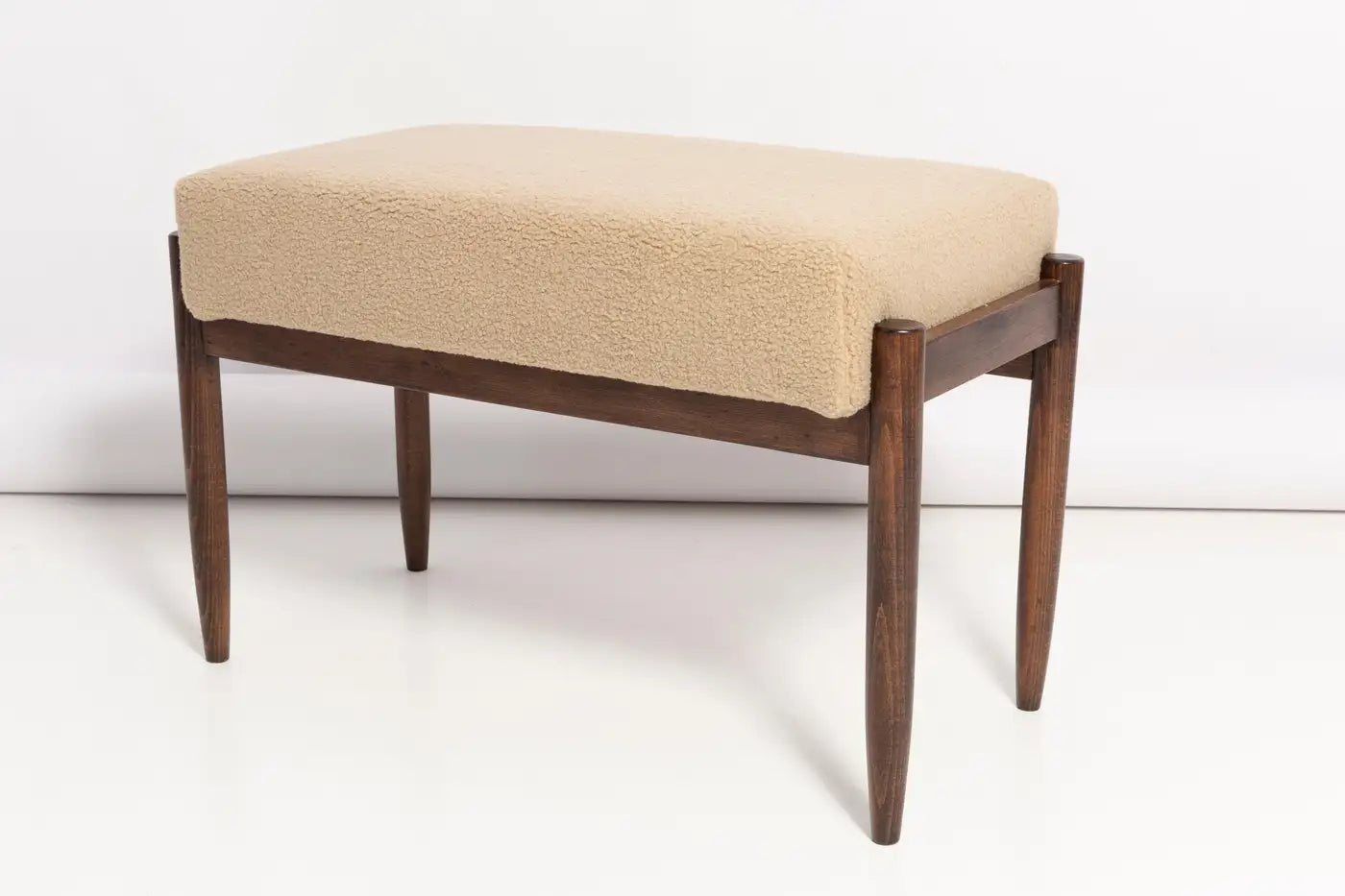 Wooden bench with beige cushion on a white background
