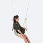 Woman sitting on a swing against a white background