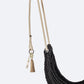 Black woven swing with beige ropes and tassels on a white background