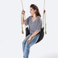 Woman sitting on a black woven swing against a white background